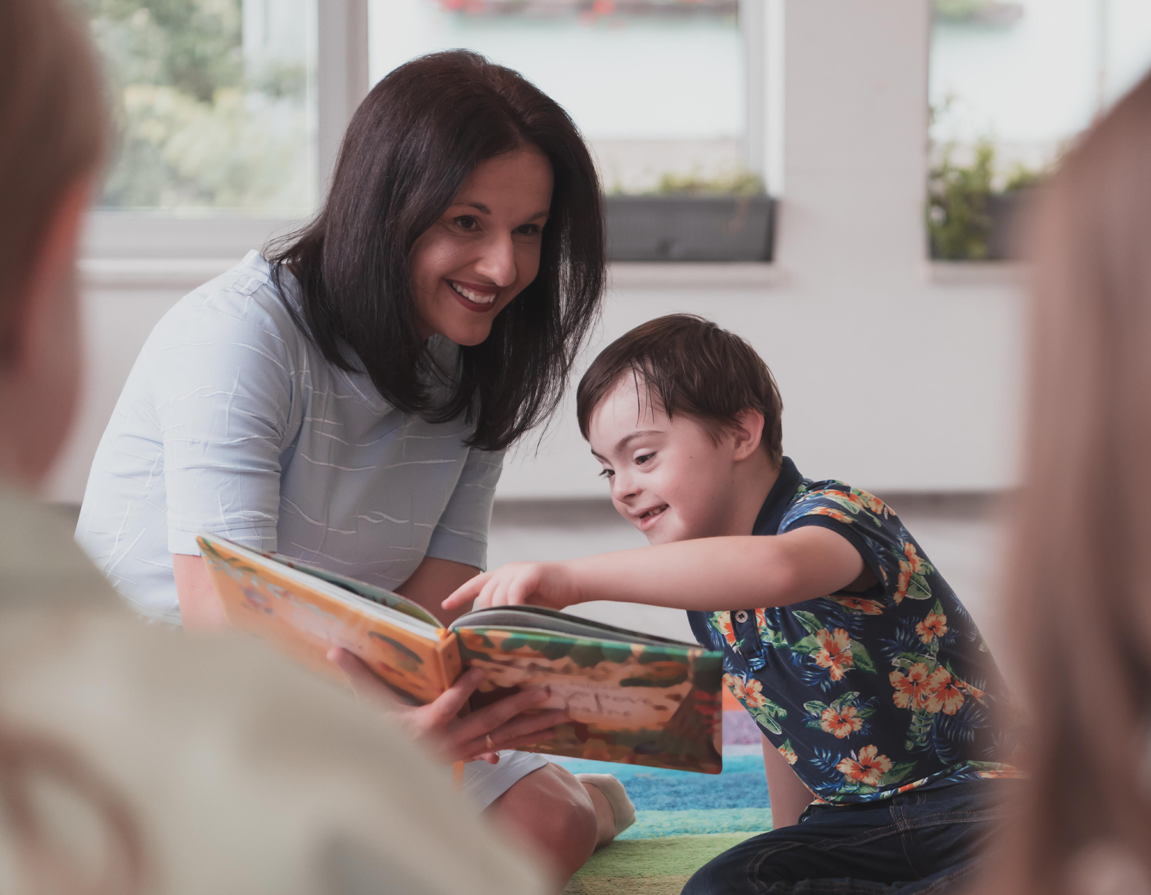 Photo of a teenage girl smiling into the camera, holding a tablet computer.